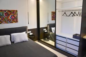 a bedroom with a bed and a large mirror at Villa LEO AIGINA in Vathí +82 photos