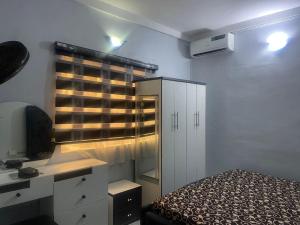 a bedroom with a bed and a desk and a window at Muniz Apartments in Lagos