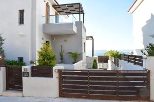 a house with a wooden fence in front of it at Villa LEO AIGINA in Vathí