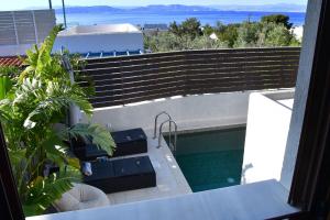 a balcony with benches and a swimming pool at Villa LEO AIGINA in Vathí