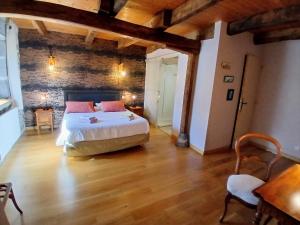 a bedroom with a large bed and a wooden floor at Le Coudi in Saint-Pierre-le-Chastel
