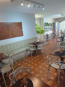 a restaurant with tables and chairs in a room at Pousada das Araras in Maceió