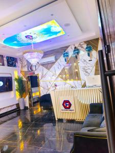 a living room with a couch and a chandelier at Fairtex Luxury Hotel in Lekki +1 photo