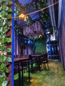 a dining room with tables and chairs and plants at Fairtex Luxury Hotel in Lekki