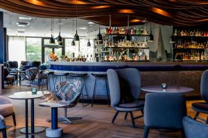 a bar with chairs and tables in a restaurant at Motel One Hamburg-Alster in Hamburg