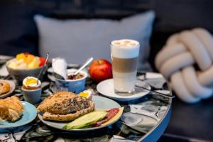 a table topped with plates of food and a drink at Motel One Hamburg-Alster in Hamburg