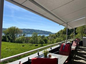 a porch with a table and chairs and a view of a lake at Hotel Landhaus Sternen in Sipplingen