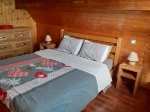 a bedroom with a bed and two tables with lamps at Chambres IM-BERG in Metzeral