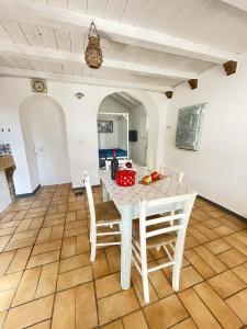 a kitchen and dining room with a white table and chairs at Casa Collina - Giardino in Pisticci