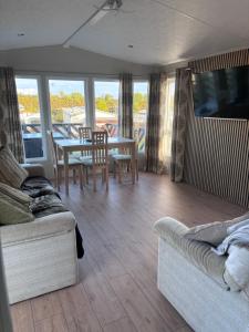 a living room with a couch and a table and chairs at ty newydd leisure park in Brynteg