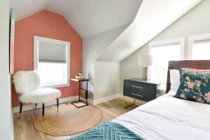 a bedroom with a bed and a chair and a window at The Smith - Renovated 4 Bedroom in Bloomfield