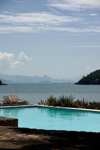 a swimming pool with a view of the water at Santa Clara Hotel in Paraty