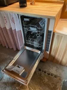an open refrigerator with a dish rack in it at Stöckli Gantrisch-Blick in Rüeggisberg