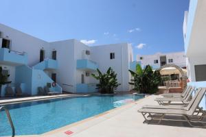 a villa with a swimming pool and lounge chairs at Platanes Hotel Apartments Rethymno in Platanes