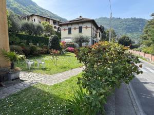 a house with a garden with flowers and plants at Limonta, Fiori e Lago Private Apartment in Limonta