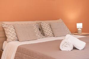 a white bed with pillows and a blanket on it at Kleos Apartment in Schisò