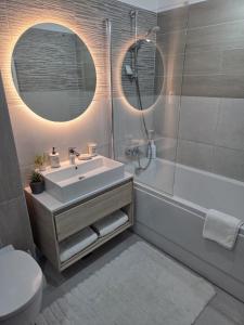 a bathroom with a sink and a tub and a toilet at Wonderful Apartment in Braşov +16 photos