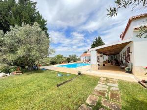 a backyard with a swimming pool and a house at Casa dos Cedros in Bicas