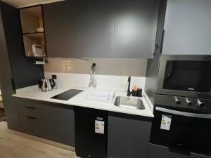 a small kitchen with a sink and a microwave at Ápice del bosque in Temuco