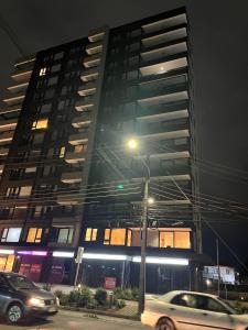 a tall building with cars parked in front of it at Ápice del bosque in Temuco