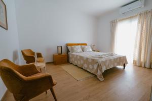 a bedroom with a bed and a chair and a window at Casas Caiado Two Houses with swimming POOL in Faro +43 photos