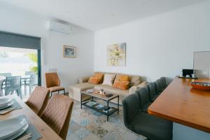 a living room with a couch and a table at Casas Caiado Two Houses with swimming POOL in Faro