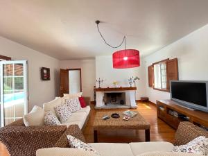 a living room with a couch and a fire place at Casa dos Cedros in Bicas
