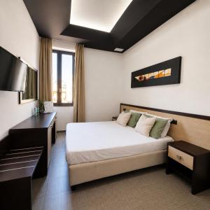 a hotel room with a bed and a desk at Boteco B&B in Bacoli