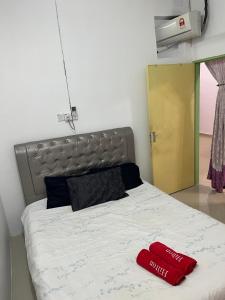 a bed with a red mitt sitting on top of it at Homestay Jerantut in Jerantut +7 photos