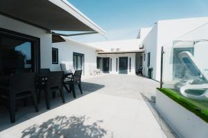 a patio with a table and chairs on a house at Casas Caiado Two Houses with swimming POOL in Faro