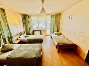 a hotel room with three beds and a window at Amonit 35 in Podlesice +18 photos