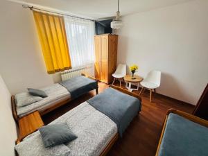 a bedroom with two beds and a table and a window at Amonit 35 in Podlesice