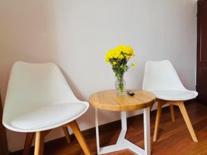 two white chairs and a table with a vase of flowers at Amonit 35 in Podlesice