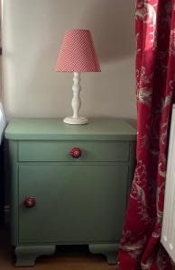 a green dresser with a lamp on top of it at Ferienhaus Bothmer in Schwarmstedt