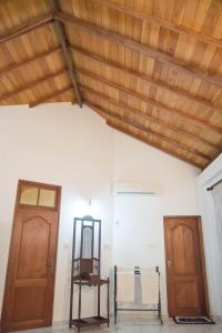 a room with a wooden ceiling and two doors at Paradise Bay in Beruwala