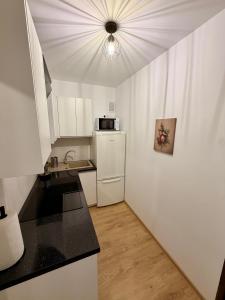 a kitchen with a white refrigerator and a microwave at Muranów Rooms Warsaw in Warsaw