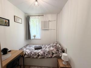 a small bedroom with a bed in the corner at Muranów Rooms Warsaw in Warsaw