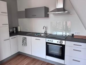 a white kitchen with a sink and a stove at Hard to leave in Piesport