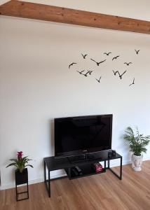 a living room with a tv and birds on the wall at Hard to leave in Piesport