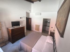 a bedroom with a bed and a dresser with a television at Residenza Borgo Francescano in Gioia del Colle