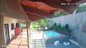 a person walking by a swimming pool in a house at Rancho Macalé Balneário de Rancharia Sp in Rancharia