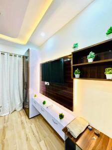 a living room with a large television on a wall at Gr Noida Stay & BNB in Greater Noida