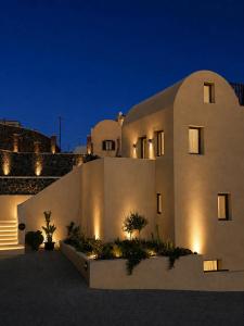 a large white building at night with lights at Hygge Villa Santorini in Pyrgos