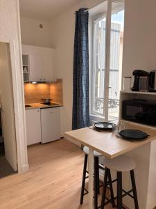a kitchen with a wooden table and a counter top at Studio de Dallet - Coeur de Ville in Clermont-Ferrand
