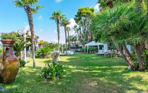 a yard with palm trees and a large vase at Complesso Villa Le Palme in Forio d'Ischia