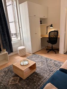 a living room with a coffee table and a desk at Studio de Dallet - Coeur de Ville in Clermont-Ferrand
