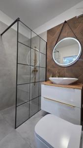 a bathroom with a sink and a mirror at Prestige Slow Lake Centrum Jezioro Magistrackie 100m Internet in Mrągowo +9 photos