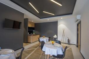 a dining room with two tables and a kitchen at Apartamenty D20 in Rybnik