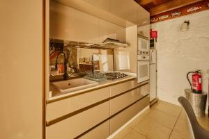 a small kitchen with a sink and a stove at Miragem do Douro in Marco de Canaveses