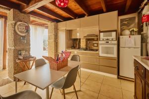 a kitchen with a table and chairs in a room at Miragem do Douro in Marco de Canaveses
